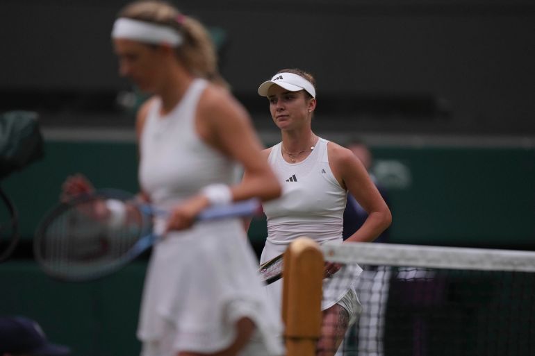 Ukraine's Elina Svitolina, right, and Victoria Azarenka of Belarus walk to their chairs after Svitolina won the women's singles match on day seven of the Wimbledon tennis champio<em></em>nships in London, Sunday, July 9, 2023. (AP Photo/Alberto Pezzali)