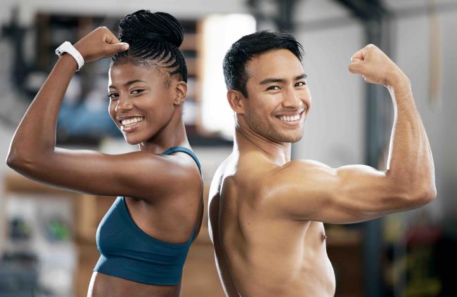 Portrait, black woman or coach flexing muscle or body goals in training or fitness exercise at gym. Coaching results, happy friends or healthy sports athletes with strong biceps, motivation or focus.