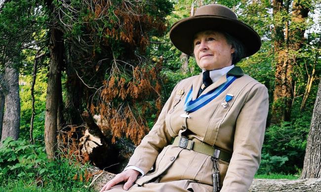 Juliette Gordon Low seated on log