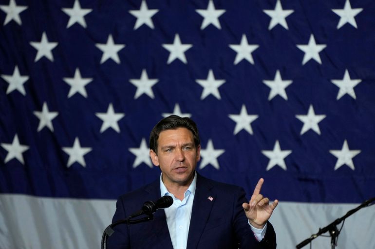 Ron DeSantis speaks with a large US flag in the background