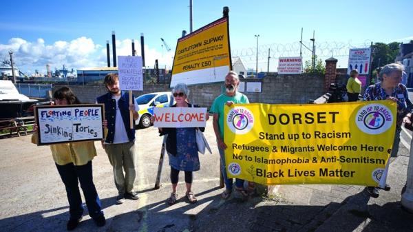 Protestor outside Portland Port in Dorset before the first asylum seekers arrive to board the Bibby Stockholm accommodation barge. The Home Office have said around 50 asylum seekers would board the Bibby Stockholm, with the numbers rising to its maximum capacity over the coming months, despite safety co<em></em>ncerns raised by some of the county&#39;s Co<em></em>nservative MPs and locals. Picture date: Mo<em></em>nday August 7, 2023. PA Photo. See PA story POLITICS Migrants. Photo credit should read: Ben Birchall/PA Wire    