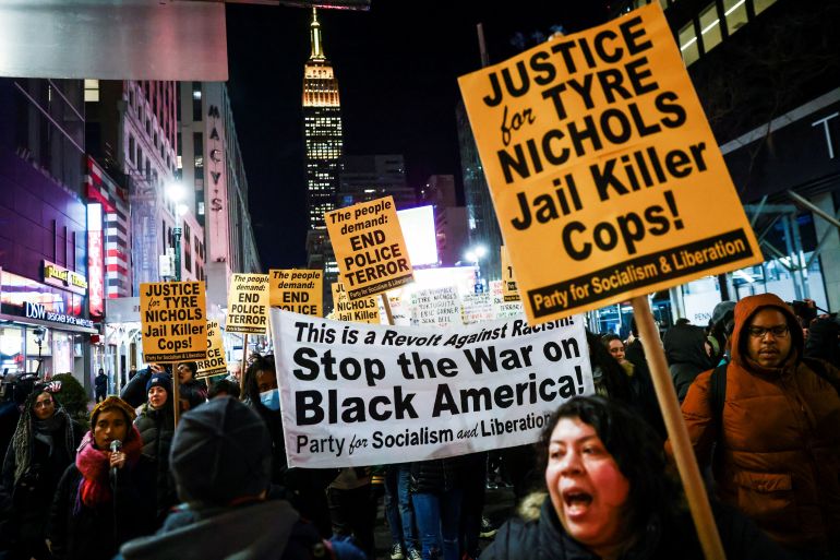 People carry a banner and signs during a protest on the day of the release of a video showing the Memphis police beating of Tyre Nichols, the young Black man who died while hospitalized three days after he was pulled over while driving by Memphis police officers, at a protest in New York, U.S., January 27, 2023. REUTERS/Andrew Kelly