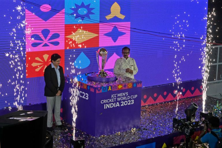 President of Cricket Association of Bengal (CAB) Snehasish Ganguly, left, and Arup Biswas, Minister of sports in Indian state of West Bengal pose with the ICC Cricket World Cup trophy