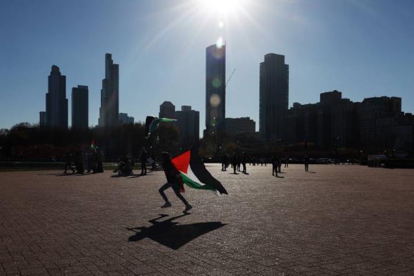 A child runs with a Palestine flag during a rally calling for a cease-fire in the Israel-Hamas war, at Buckingham Fountain in Chicago on Nov. 18, 2023. Teachers at Universal School have run into their students at some of the high-profile rallies, protests and other actions in Chicago supporting Palestinians in Gaza.