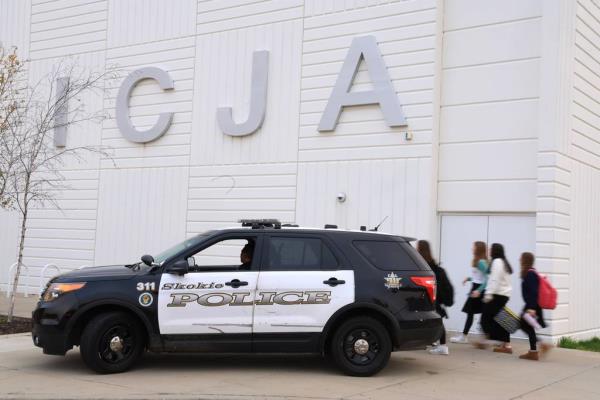 Skokie police Officer Jon Mendoza sits in his vehicle and mo<em></em>nitors activity as students head in for the school day at Ida Crown Jewish Academy on Oct. 27, 2023.  