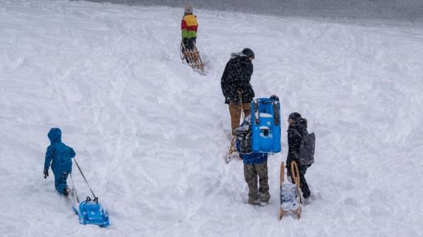 02 December 2023, Bavaria, Munich: Adults with children and sledges walk up the hill behind the Landtag. Photo by: Peter Kneffel/picture-alliance/dpa/AP Images