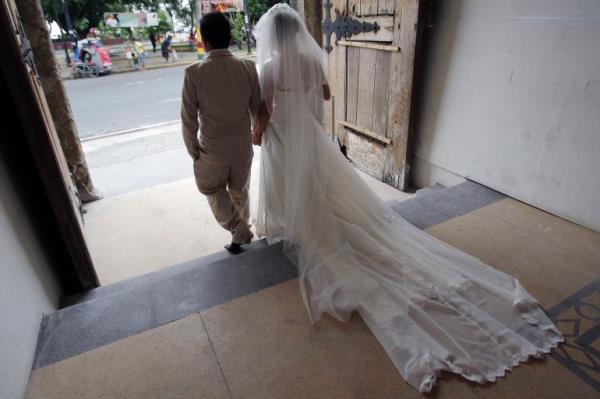 A newlywed Filipino couple walk out of a church