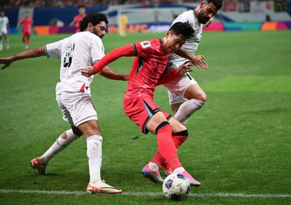 South Korea's Son Heung-min (C) fights for the ball with Palestine's Attaa Jaber (L) and Musab Battat (R) during the FIFA World Cup 2026 Asia zone qualifiers football match between South Korea and Palestine in Seoul on September 5, 2024. (Photo by Jung Yeon-je / AFP)