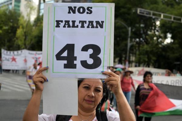 A woman holds a banner that reads in spanish "We have 43 missing" as she takes part in a march to demand justice in the case of the disappearance of 43 students from the Ayotzinapa teaching training school in 2014, one mo<em></em>nth before to commemorate the 10th anniversary in Mexico City on August 26, 2024. (Photo by Yuri CORTEZ / AFP)