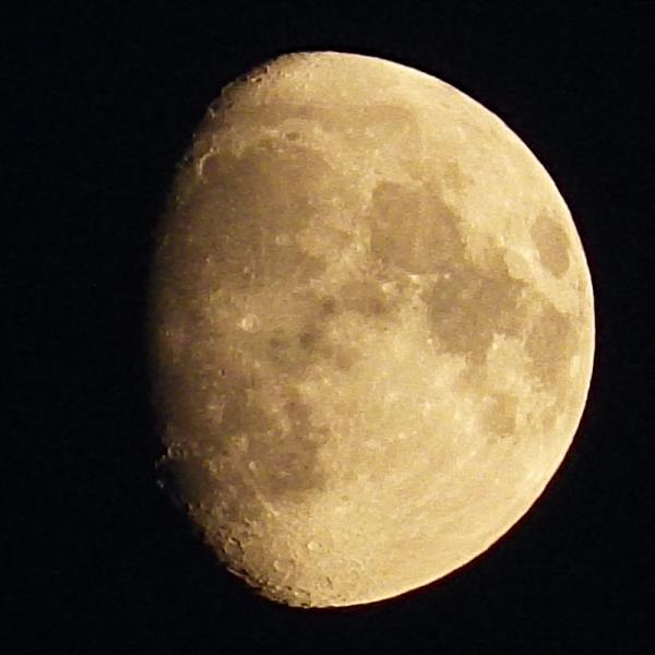 Yellowish waxing gibbous moon.