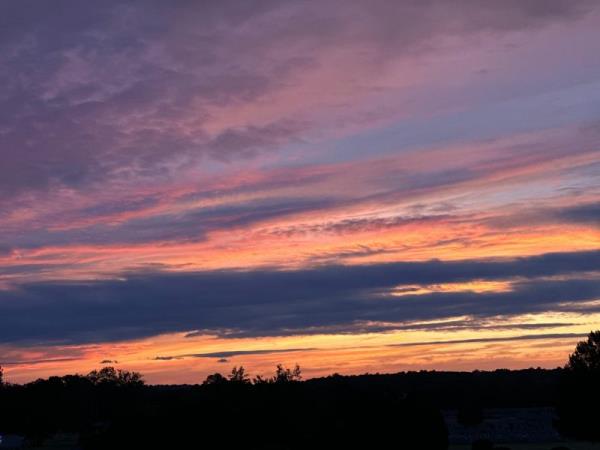 Layered sunset with clouds, including dark indigos and orangey pinks.