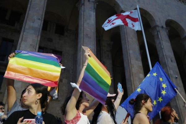 Participants hold flags during a rally in support of those who were injured during the July 5 protests, when a pride march was disrupted by members of violent groups