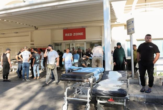 People gather outside a hospital, as hundreds of members of the Lebanese armed group Hezbollah, including fighters and medics, were seriously wounded on Tuesday