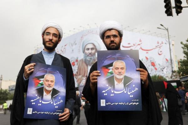 Iranians hold posters of assassinated Hamas chief, Ismail Haniyeh during his funeral procession, in Tehran, Iran, August 1, 2024. Majid Asgaripour/WANA (West Asia News Agency) via REUTERS ATTENTION EDITORS - THIS IMAGE HAS BEEN SUPPLIED BY A THIRD PARTY.