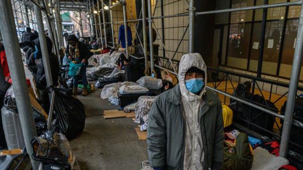 TOPSHOT - Migrants camp outside a hotel wher<em></em>e they had previously been housed, as they resist efforts by the city to relocate them to a Brooklyn facility for asylum seekers, in the Hells Kitchen neighborhood of New York on January 31, 2023. (Photo by Ed Jo<em></em>nES / AFP) (Photo by ED JONES/AFP via Getty Images)