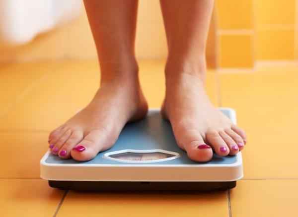 woman's feet on scale, co<em></em>ncept of how to lose one pound