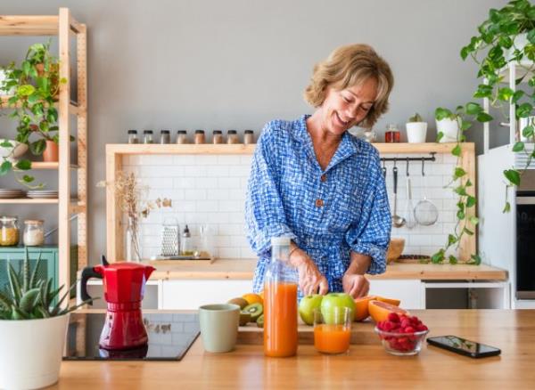 woman preparing healthy meal in bright kitchen, co<em></em>ncept of feeling flabby at 50