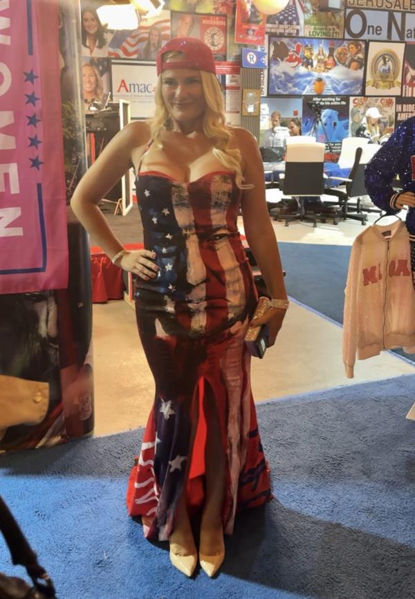 A woman wears an American flag-patterned gown featuring former president Do<em></em>nald Trump's face