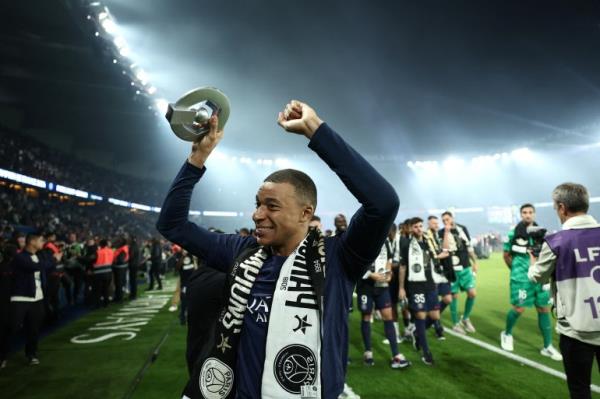 Paris Saint-Germain's French forward Kylian Mbappe celebrates with the French Ligue 1 championship's trophy during a ceremony following the French L1 football match between Paris Saint-Germain (PSG) and Toulouse (TFC) on May 12, 2024 at the Parc des Princes stadium in Paris. FRANCK FIFE/Pool via REUTERS