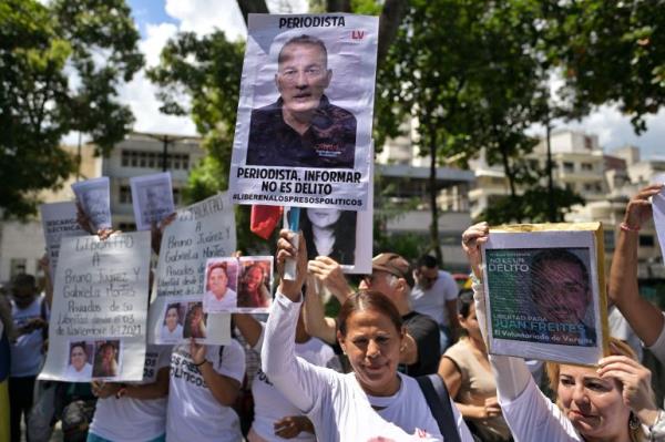 Demo<em></em>nstrators show posters of people arrested for protesting against the government of President Nicolas Maduro