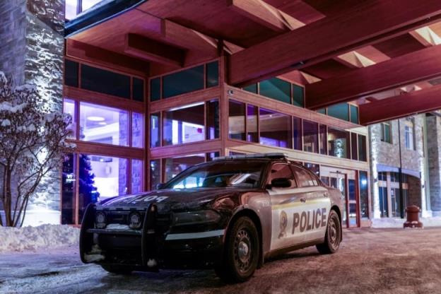 A police car parked outside a hotel. 