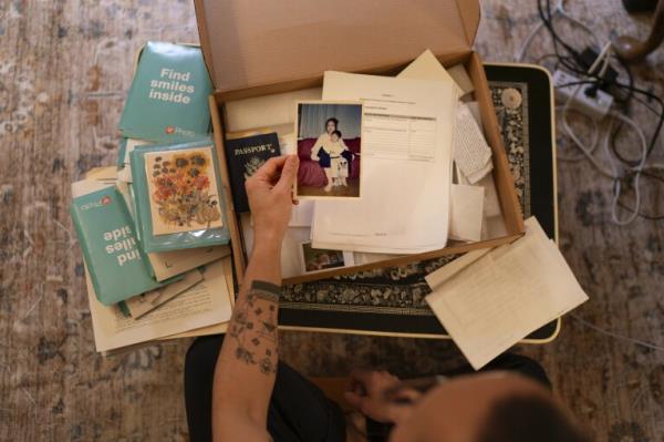 Robert Calabretta holds a picture of his biological mother and brother while sifting through family mementos at his apartment, Feb. 15, 2024, in New York. After Calabretta was adopted as a baby to an American family, hospital officials told his mother to assume he had died. (AP Photo/David Goldman)