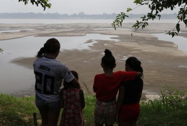 Residents look out at the Madeira River, a tributary of the Amazon River, during the dry season in Humaita, Amazo<em></em>nas state, Brazil, Saturday, Sept. 7, 2024. (AP Photo/Edmar Barros)