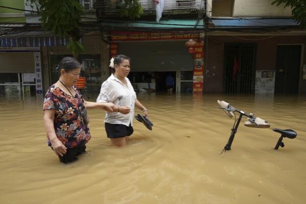 People wade in a flooded street in the aftermath of Typhoon Yagi, in Hanoi, Vietnam on Thursday, Sept. 12, 2024. (AP Photo/Hau Dinh)