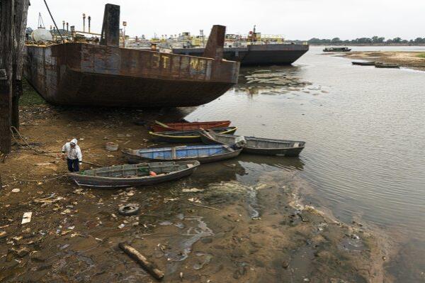 Milciades Gonzalez, who rents fishing boats, works near Puerto Pabla in Lambare, Paraguay, Thursday, Sept. 12, 2024. Go<em></em>nzalez said fish are not biting amid the record-low water level brought by drought. (AP Photo/Jorge Saenz)