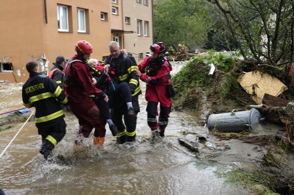 A resident is evacuated from her flooded house in Jesenik, Czech Republic, Sunday, Sept. 15, 2024. (AP Photo/Petr David Josek)