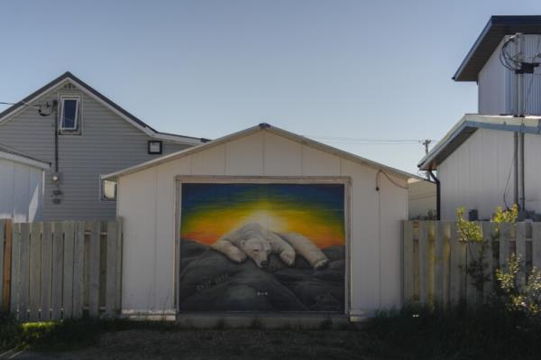 A garage displays a mural of a sleeping polar bear, Thursday, Aug. 8, 2024, in Churchill, Manitoba. (AP Photo/Joshua A. Bickel)