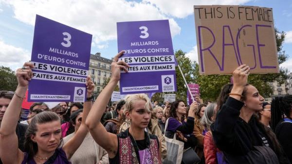 People take part in a gathering in support of 71-year-old Gisele Pelicot who was allegedly drugged by her ex-husband and raped by dozens of men while unconscious, Saturday, Sept. 14, 2024 in Paris. Placards left read, "3 billion euros to combat violence against women." (AP Photo/Michel Euler)