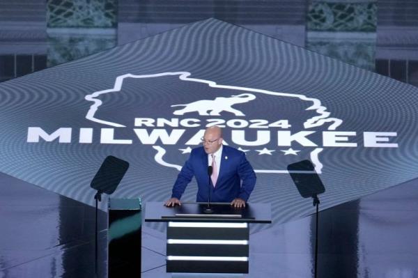 a man stands in front of a sign that says Milwaukee