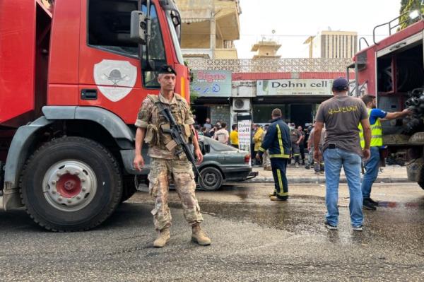 A Lebanese army soldier stands guard near fire trucks at the scene of a reported pager device explosion in Saida in southern Lebanon on September 18, 2024