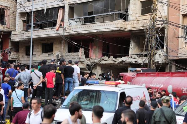 People inspect the site of an Israeli strike in the southern suburbs of Beirut.