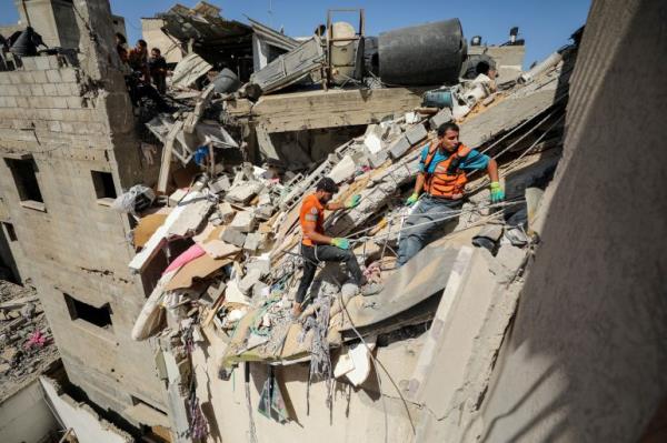 Rescuers work to recover the body of a Palestinian girl from under the rubble