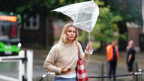 A woman battles with her umbrella during rain in Winchester, Hampshire, on 5 September. Pic: PA