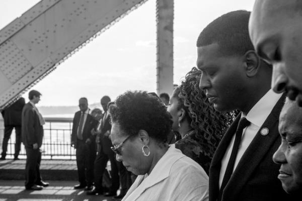 black and white image of Michael Regan praying alo<em></em>ngside community members in Selma, Alabama