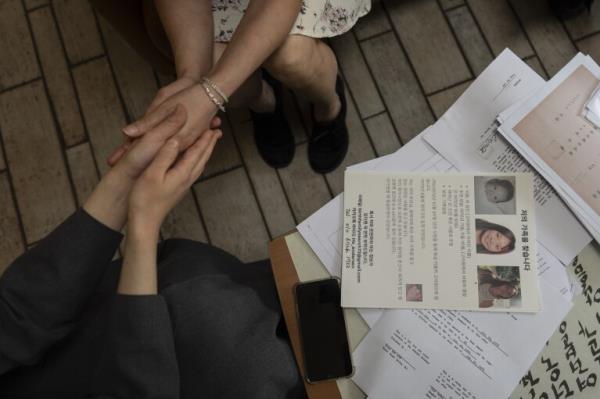 Maja Andersen, top, an adoptee visiting from Denmark to search for her birth family, holds the hands of Sister Christina Ahn at Star of the Sea orphanage in Incheon, South Korea, Monday, May 20, 2024, during her visit to look for docu<em></em>ments in hopes of finding her family. She stayed at the facility until her adoption at seven mo<em></em>nths old. (AP Photo/Jae C. Hong)