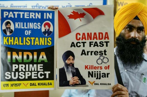 A member of a Sikh organisation holds a placard displaying Sikh separatist Hardeep Singh Nijjar