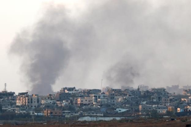 Smoke rises over a city. 