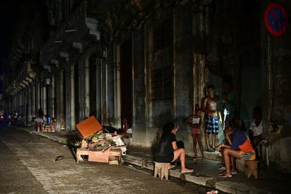 Cubans chat at night on a street during a natio<em></em>nwide blackout caused by a grid failure in Havana on October 18, 2024