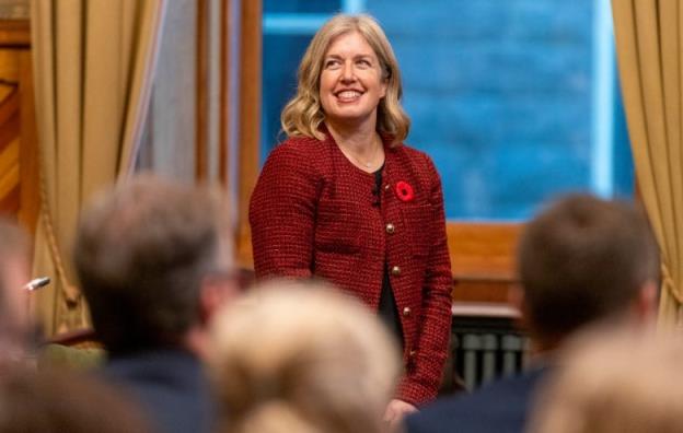 A woman smiles up at an audience.