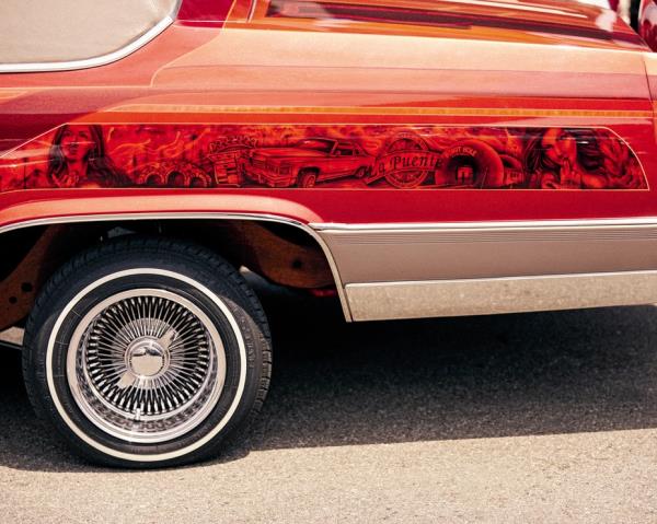 photo of side of car with detailed black mural painted on red background