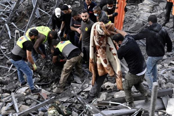 Rescuers and civilians inspect the rubble at a site targeted by an Israeli air strike, in Almat, Jbeil district, Lebanon