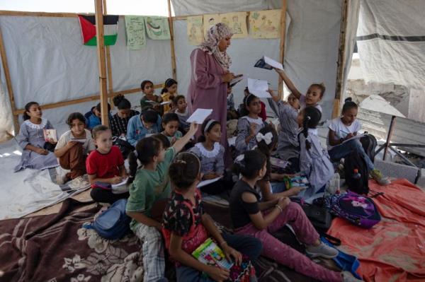 Palestinian teacher Israa Abu Mustafa teaches inside a makeshift classroom