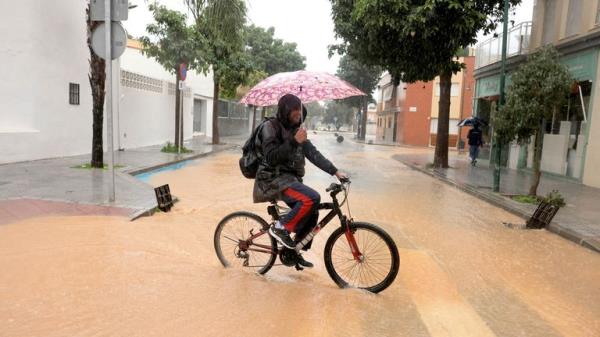 A cyclist crosses a road after the Campanillas river overflows in the Campanillas neighbourhood, after Spanish meteorological agency AEMET issued red a<em></em>lerts due to expected heavy rains, in Malaga,
Pic: Reuters