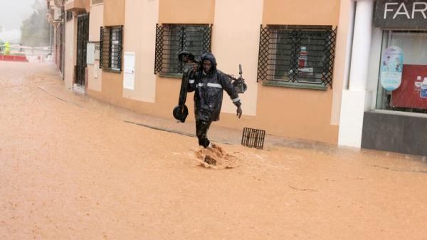 A man walks through a flooded street amid the overflow of the Campanillas river, due to heavy rains in Malaga, Spain.
Pic: Reuters