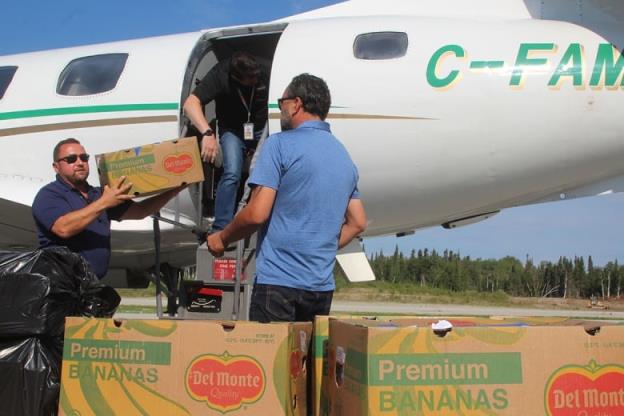 People are seen loading boxes o<em></em>nto a plane.