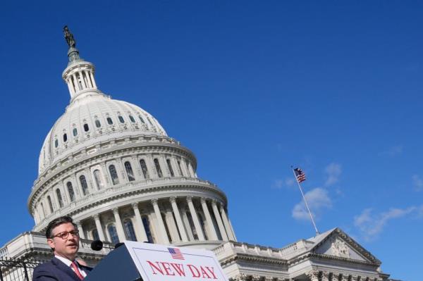 Republican Mike Johnson speaks behind a podium in front of the Capitol dome.